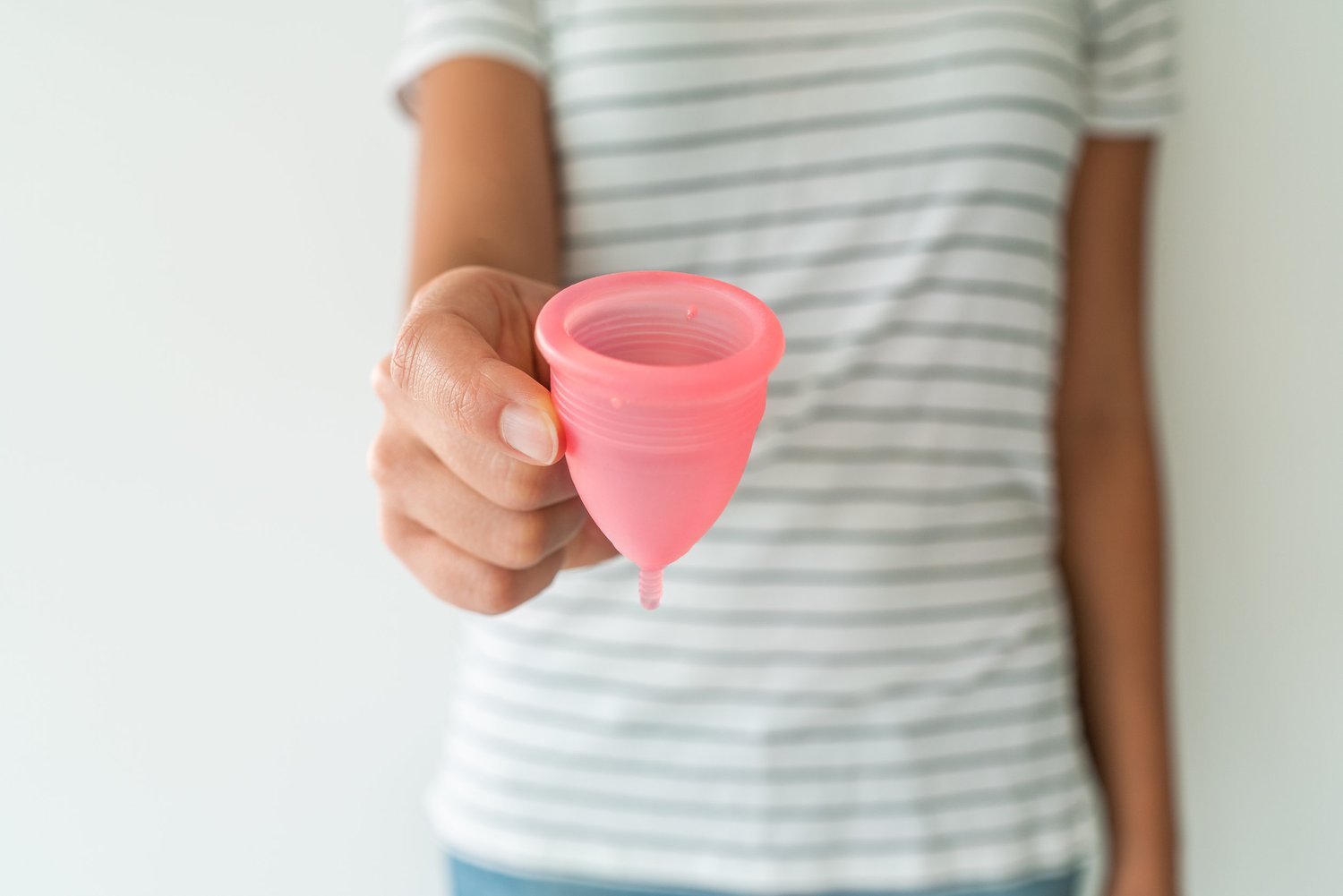 woman holding pink menstrual cup