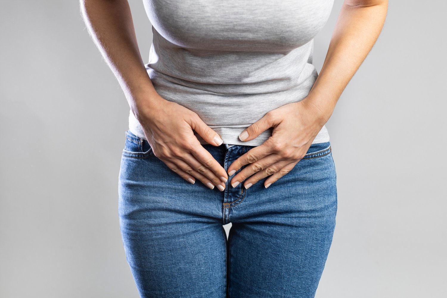 woman in jeans holding her stomach