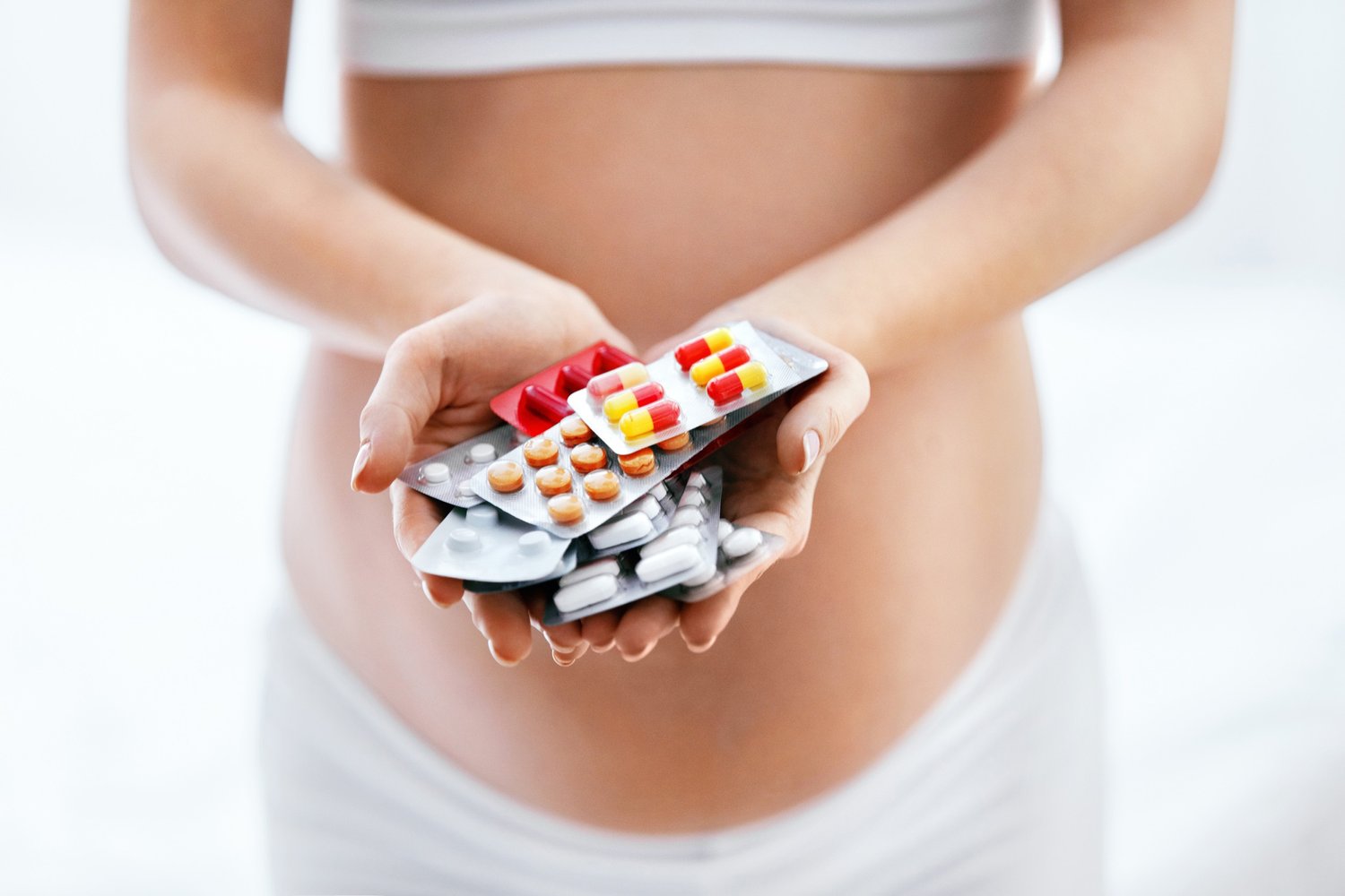 Pregnant woman holding vitamins